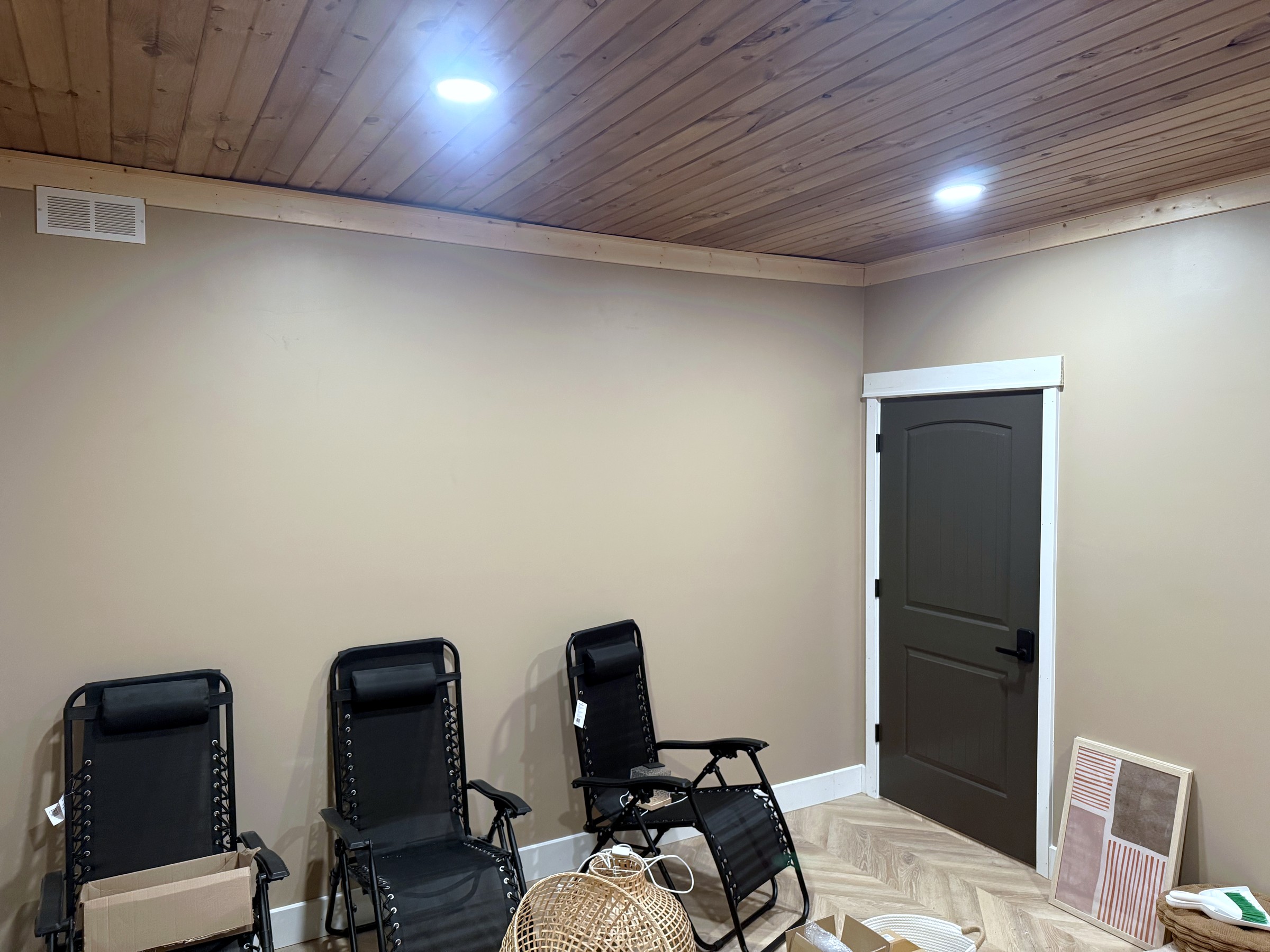 Finished basement room with painted walls, wood ceiling, and recessed lighting