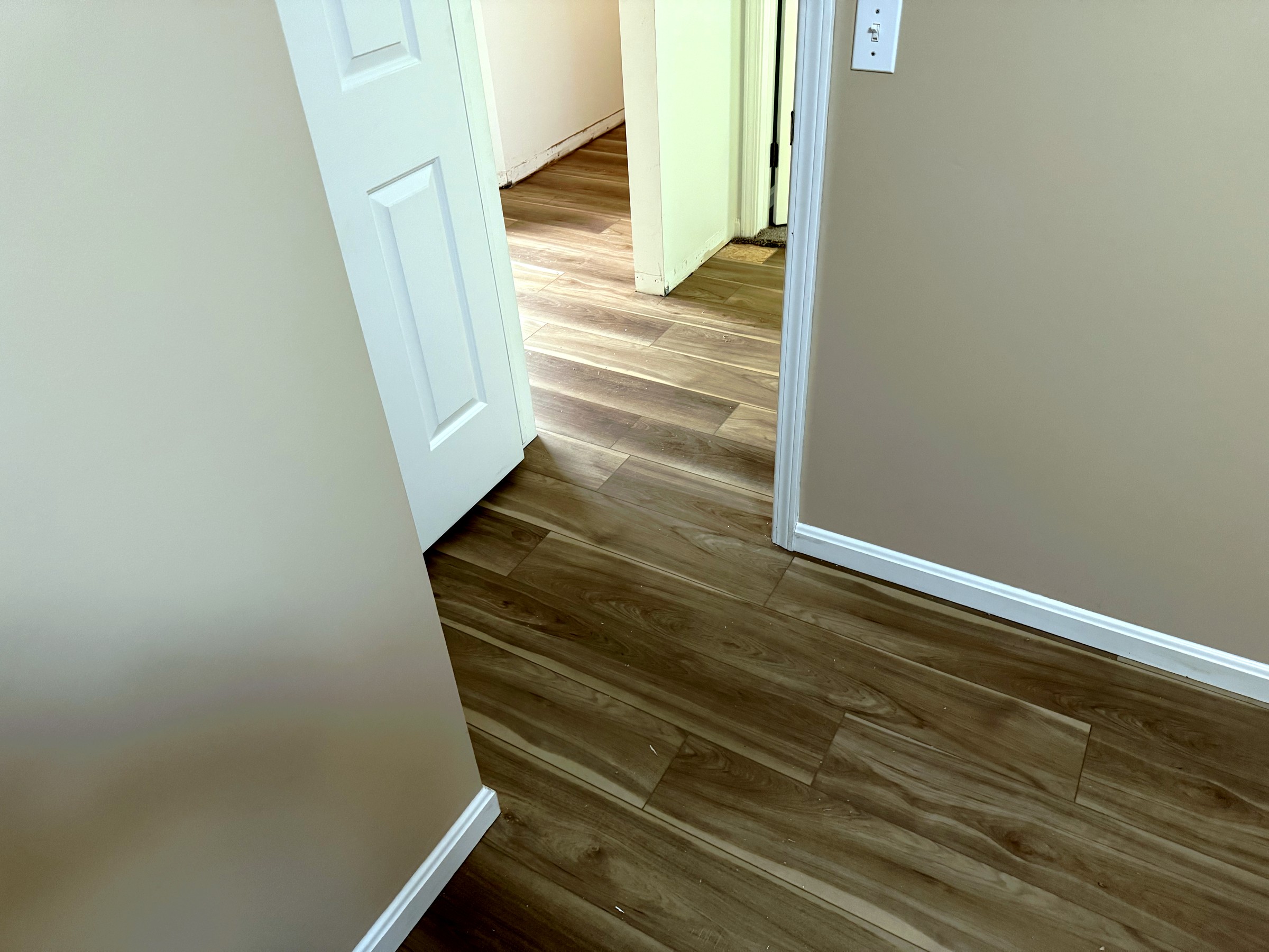 Finished flooring transitioning from hallway into a room