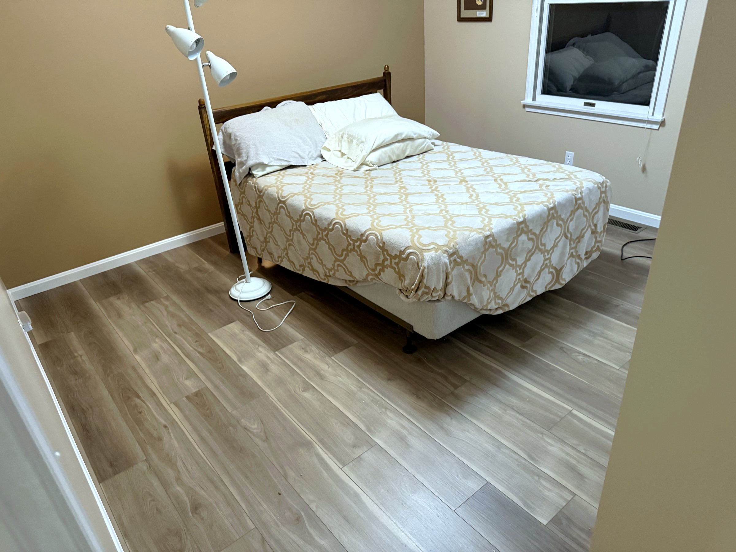 Finished wide-plank flooring in a furnished bedroom